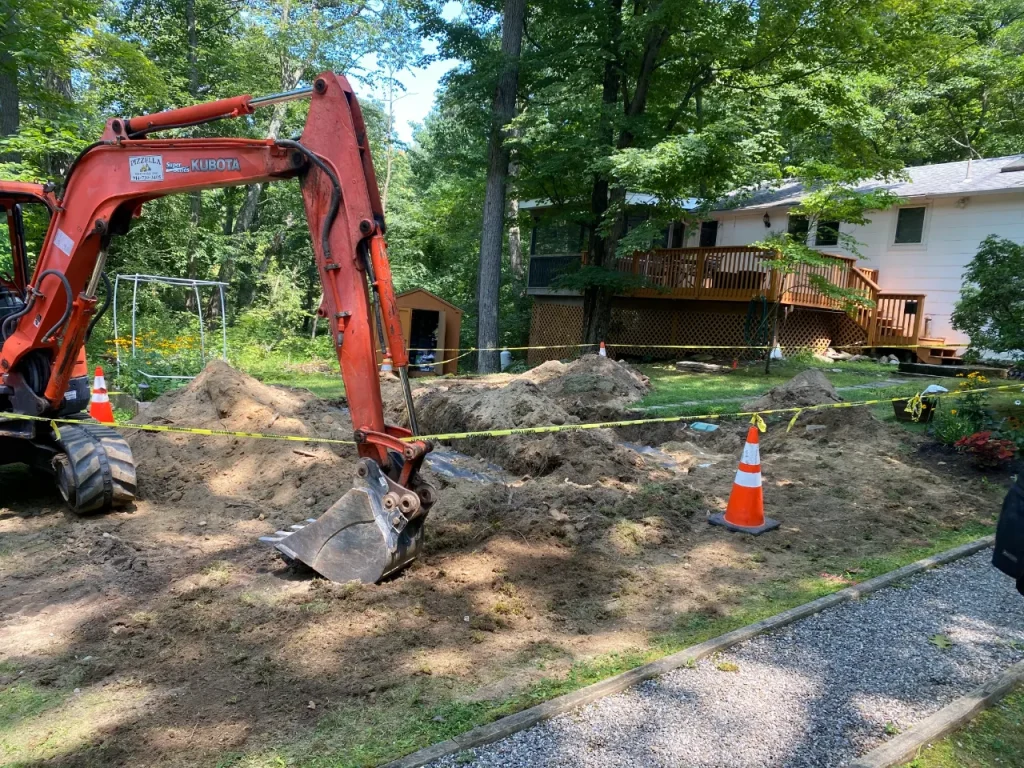 Septic trenches in side yard of a white house.